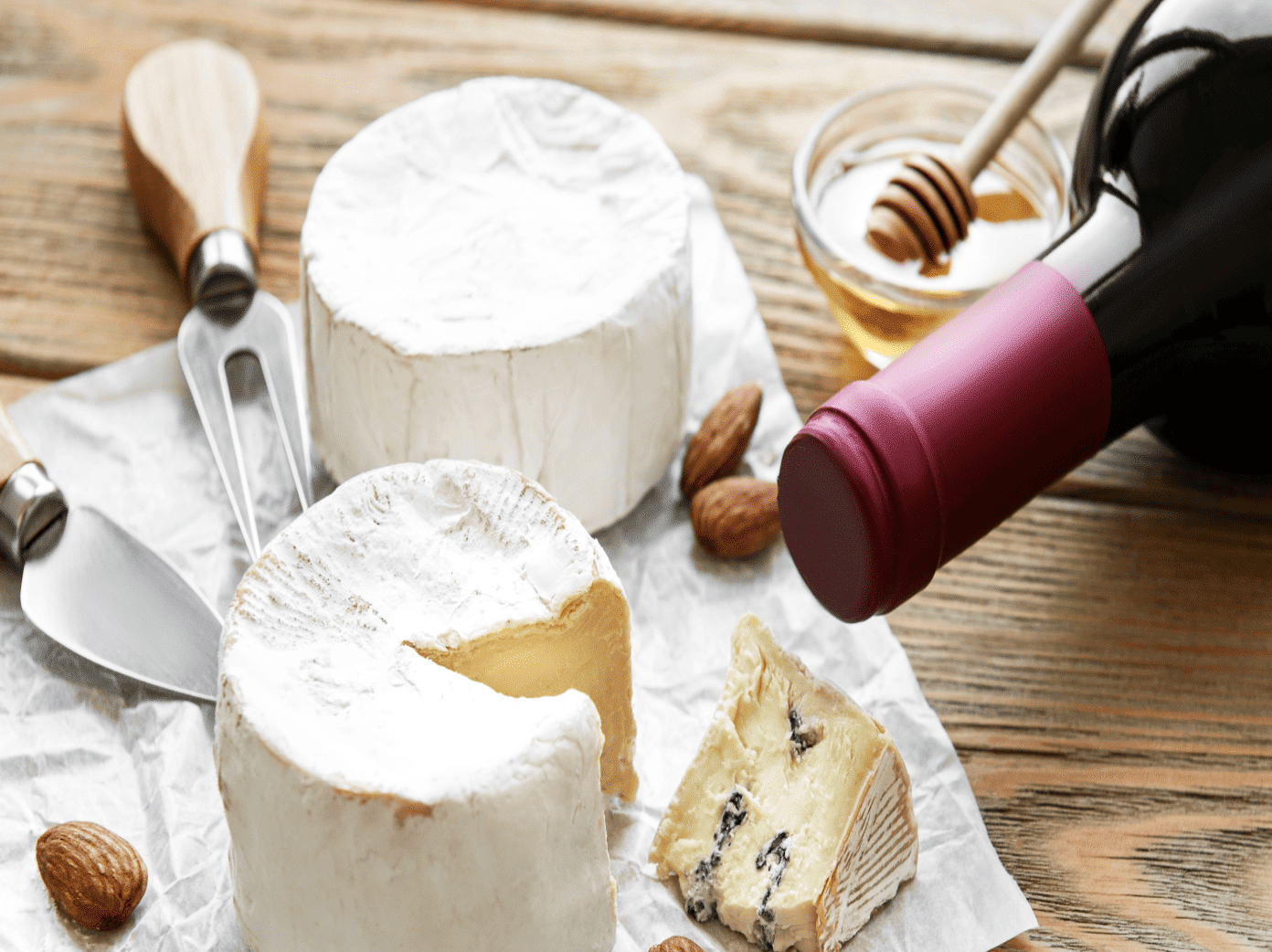 Plateau de fromages avec miel, noix et bouteille de vin